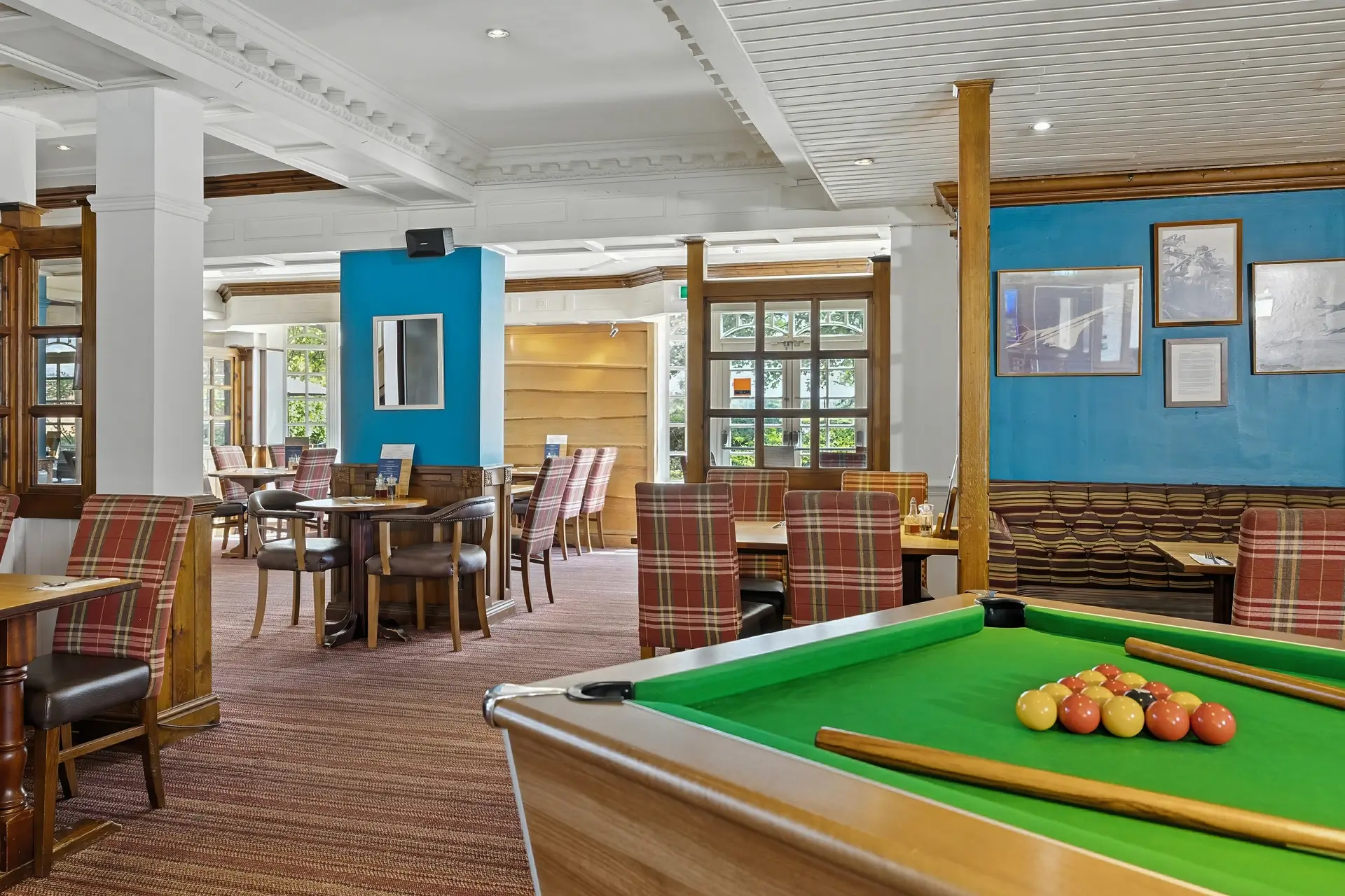 A cozy dining area featuring a green pool table in the foreground